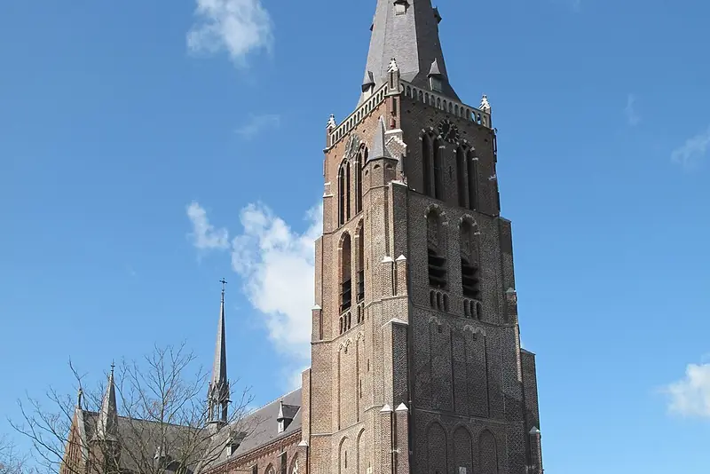 De Sint-Willibrorduskerk in Berghem met de hoge bakstenen toren
