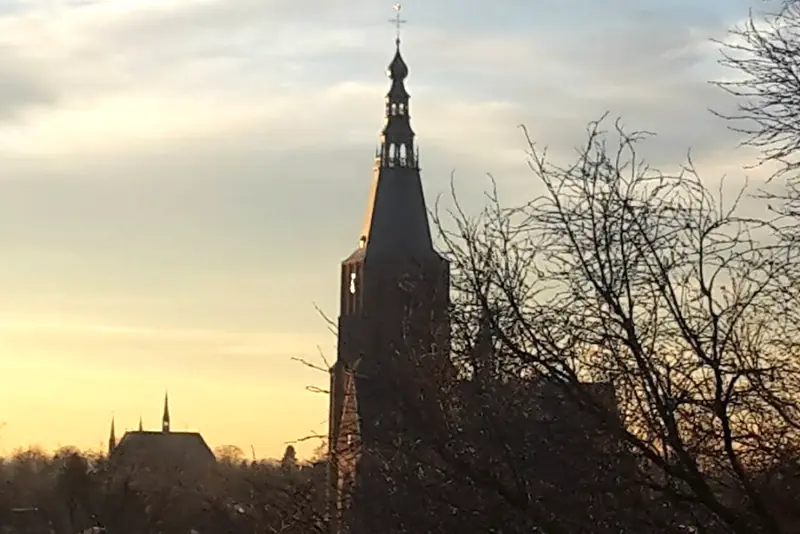 De kerktoren van Vught bij zonsondergang